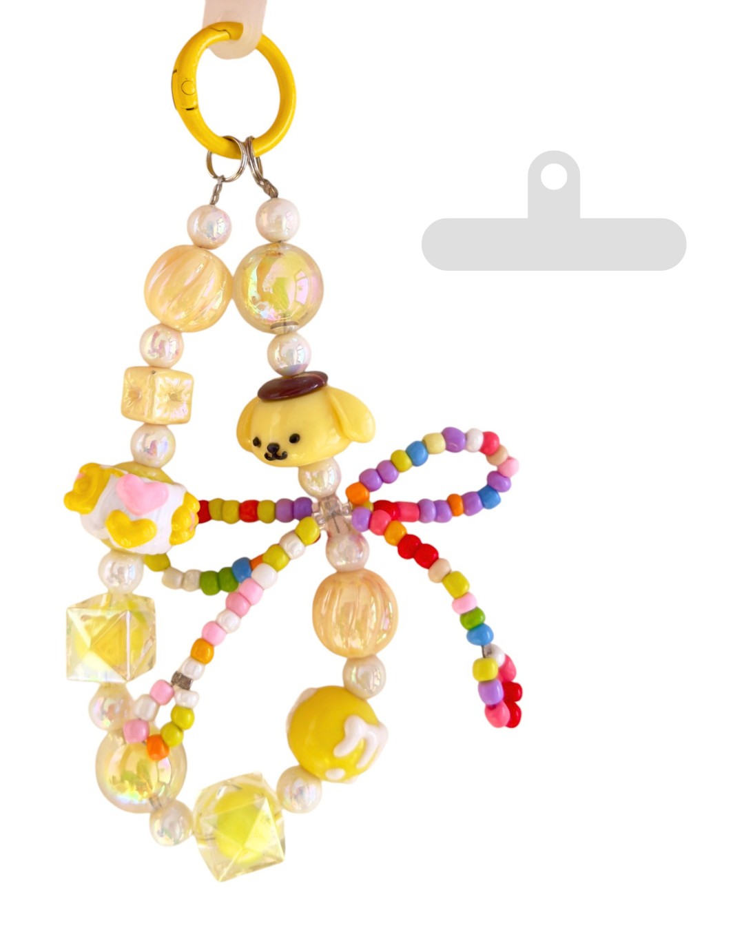 Loopsie Sunny Pup phone charm with yellow puppy beads, colorful bow, and transparent silicone attachment.